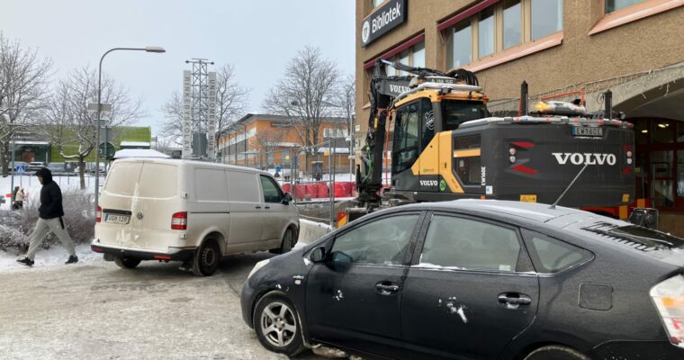 En buss och en bil trängs på en gata, som delvis är avstängd.