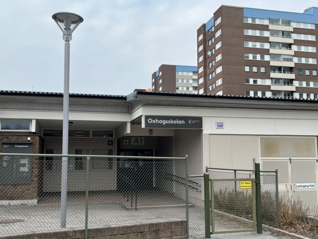 En skola i förgrunden, höghus bakom.