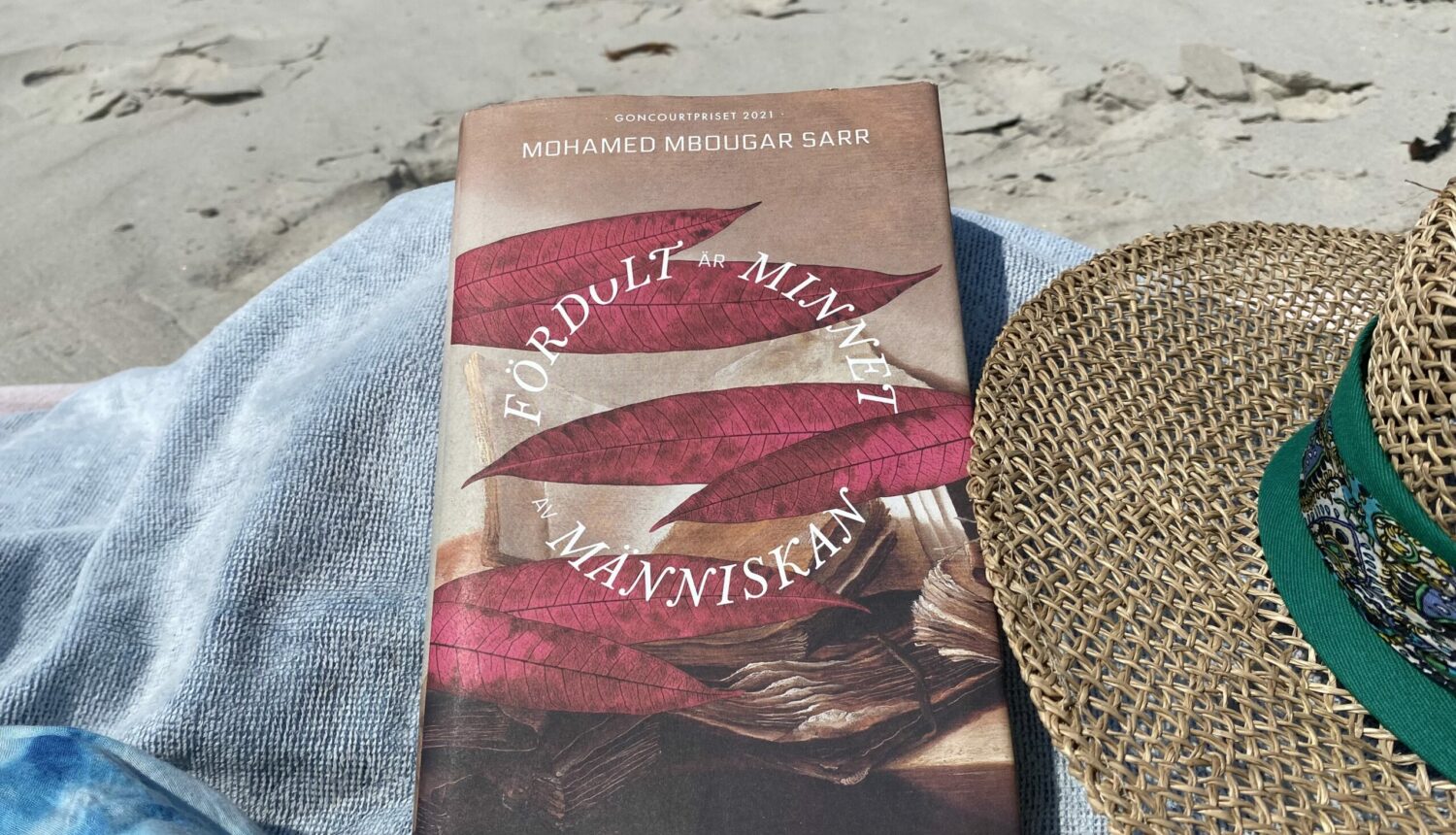 Bok ligger på en handduk på stranden