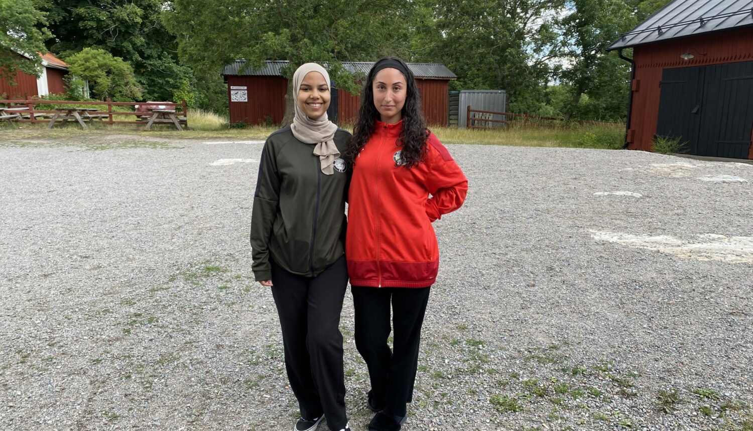 Två unga tjejer står på en gårdsplan