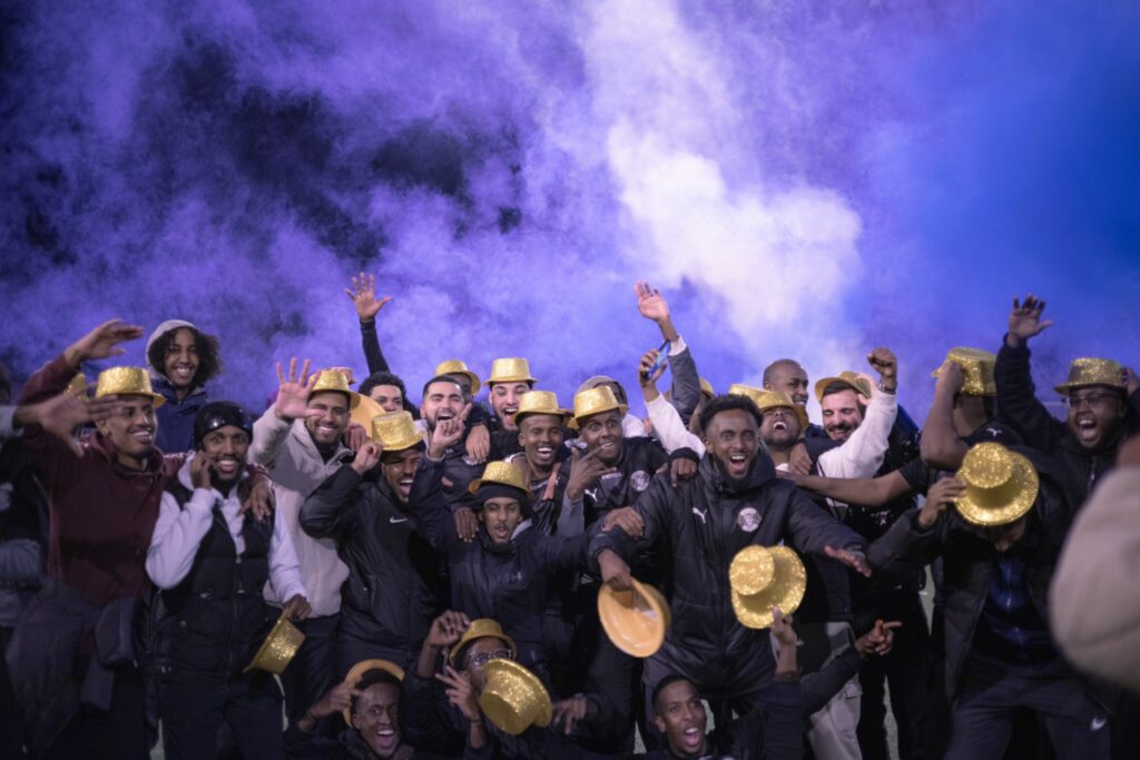 Glada fotbollsspelare i guldhattar.