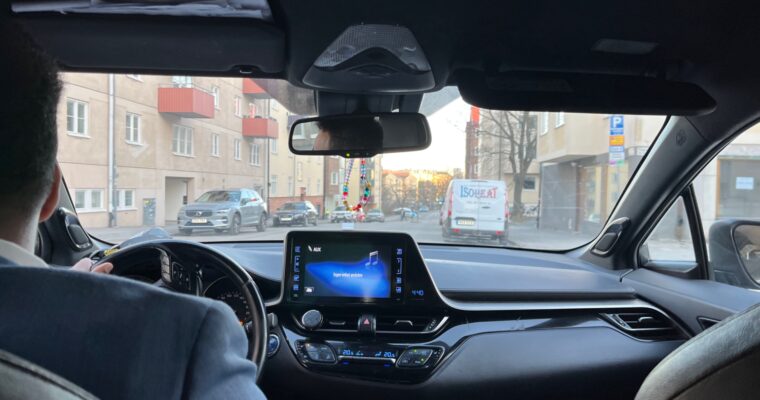 Man som sitter och kör en bil, det syns en gps.