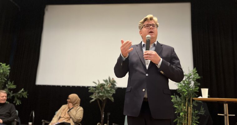 Justitieminister Gunnar Strömmer (m) talar i mikrofon på en scen.