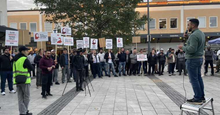 demonstranter med skyltar emot slöjförbud på ett torg