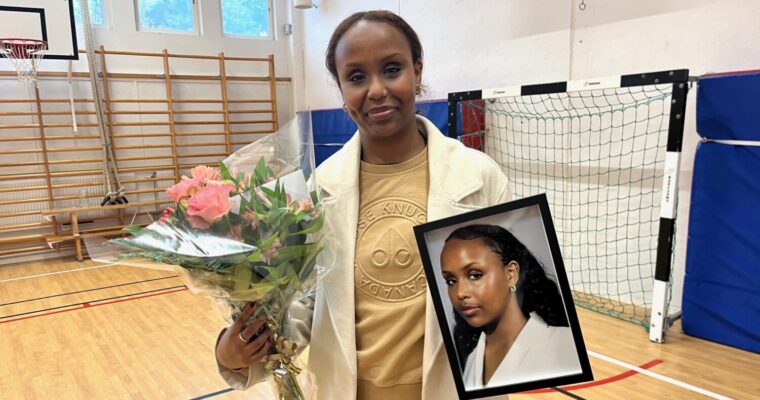 Ayan Ahmed med blombukett och inramat porträtt.