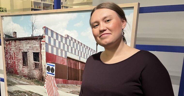 tjej ler framför ett fotokonstverk