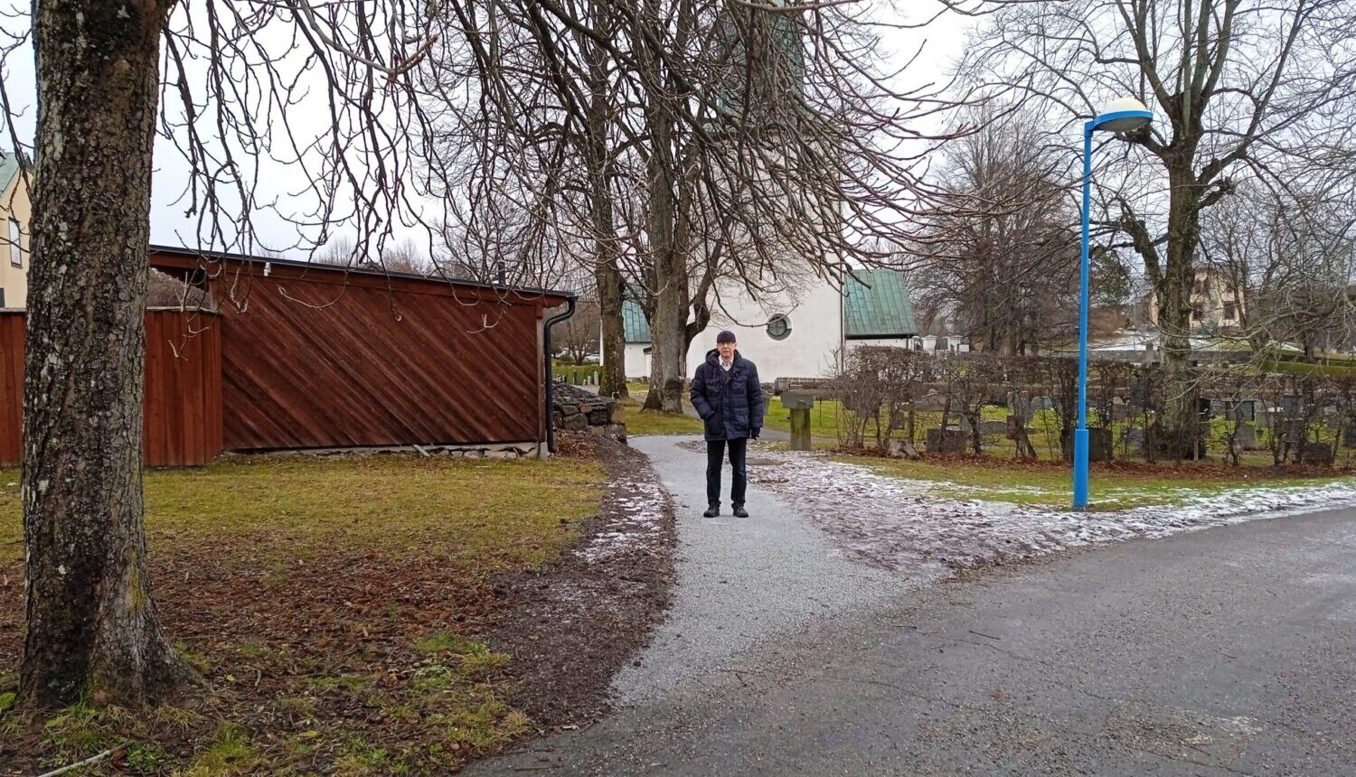 En man står på den nya gångvägen in till Spånga kyrka.