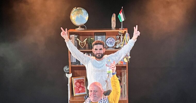 en man står bakom en äldre man, hans pappa, som sitter i rullstol