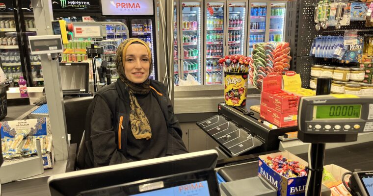 kvinna som sitter bakom en kassa