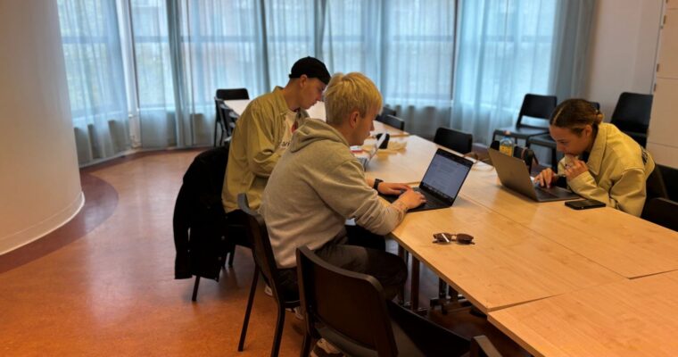 tre studenter jobbar med grupparbete i journalistik