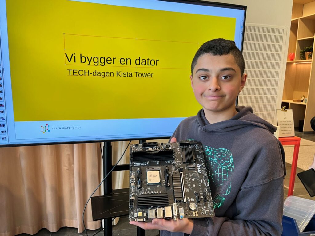 ung kille håller i datorkomponent