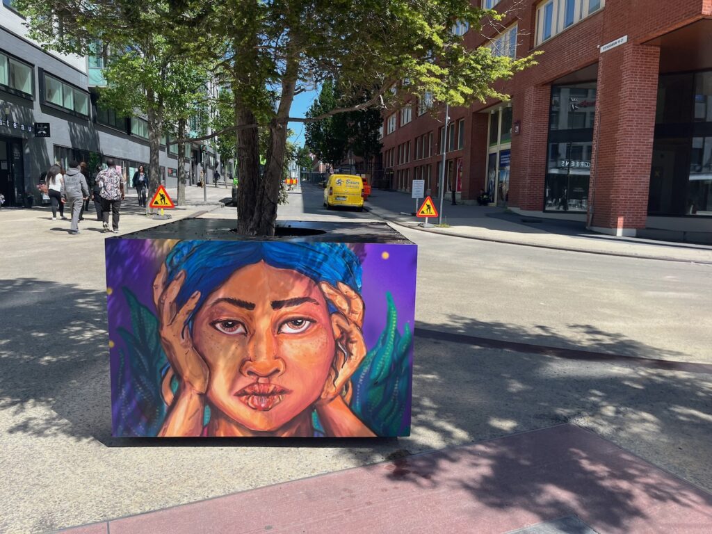 Målningen är en kvinna som lutar sitt ansikte mot sina två händer.