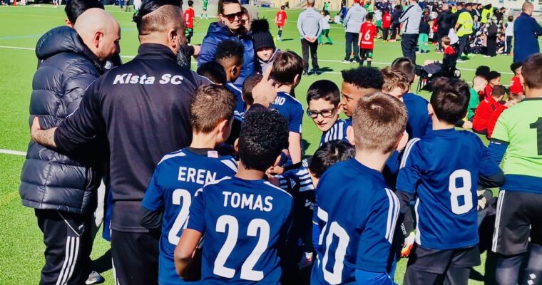 ett fotbollslag och deras tränare samlas