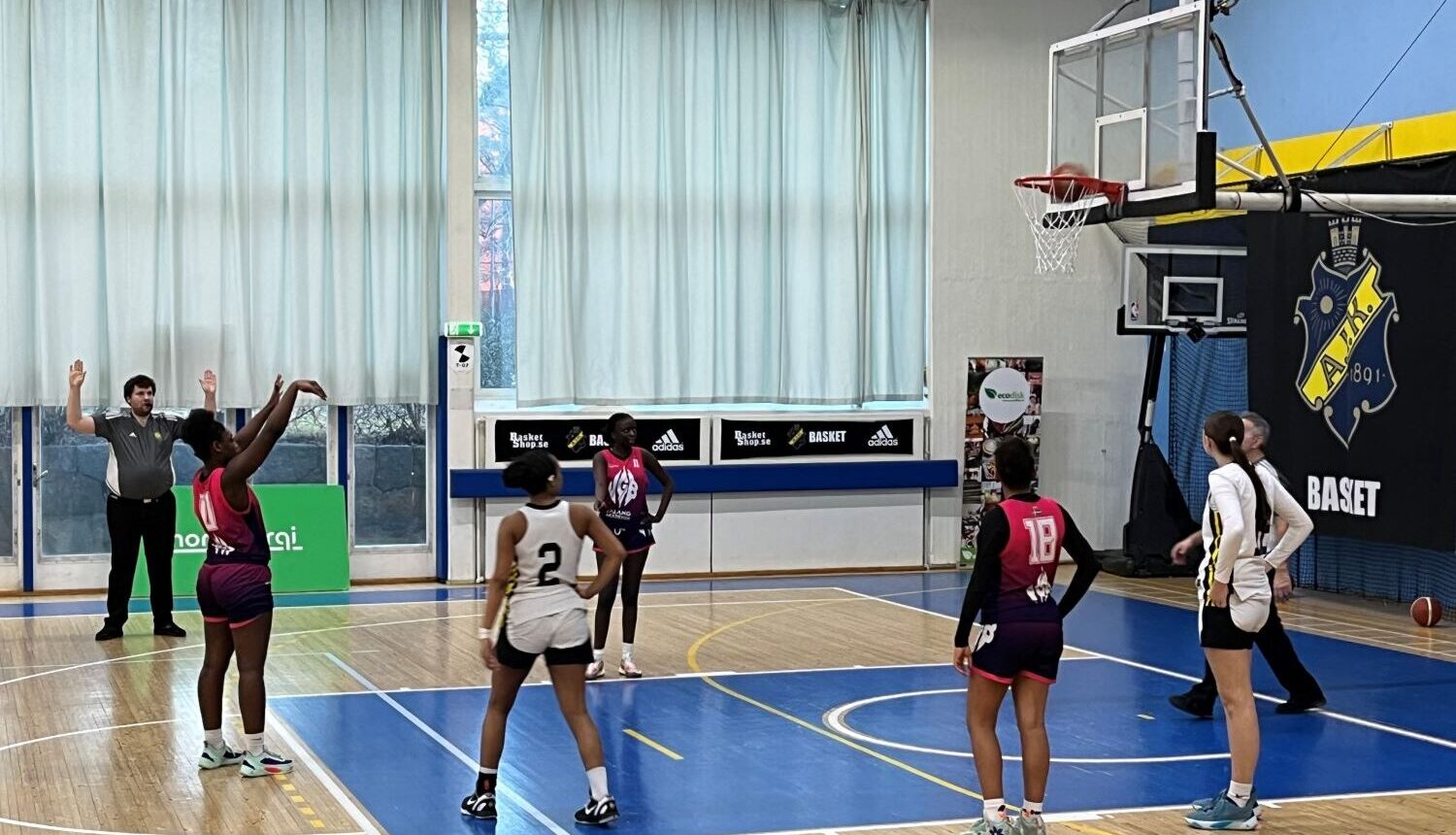 ung kvinna skjuter straff mot basketkorg