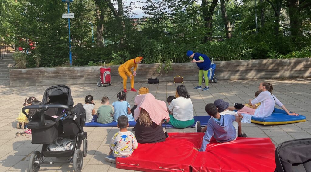 Två skådisar utklädda till sagofigurer spelar fram barnen.