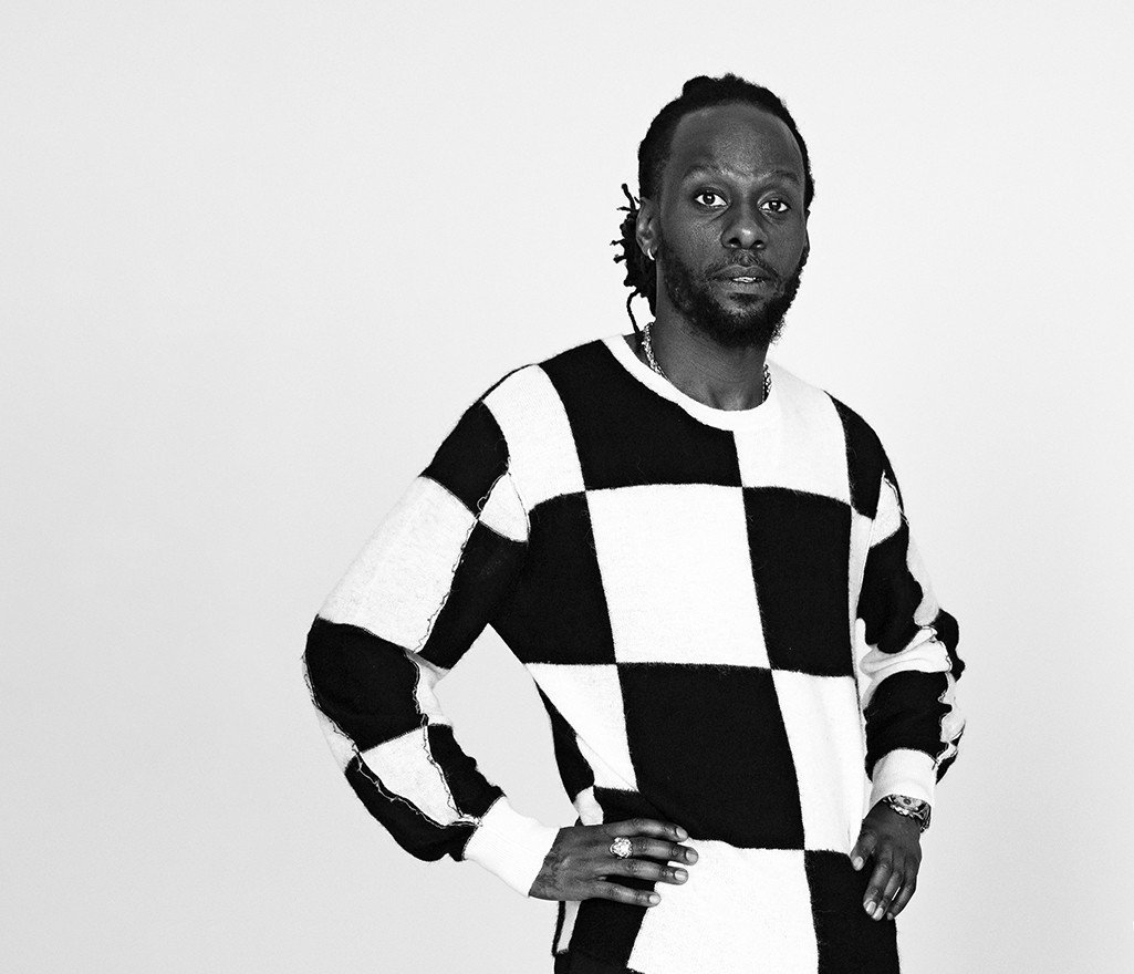 man poserar i svartrutig tröja