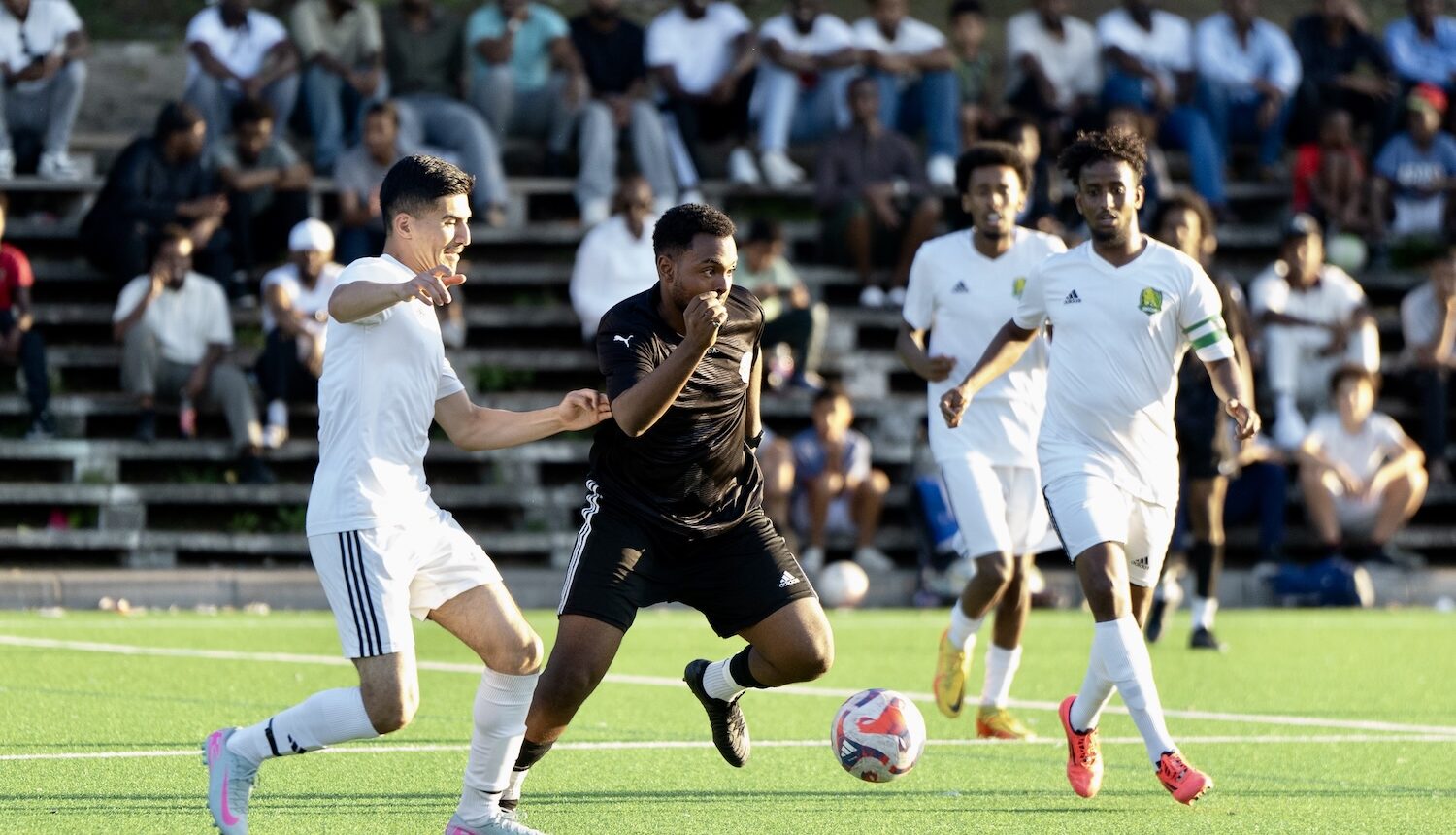 Matchbild, två lag ett i svarta tröjor och de andra i vita.