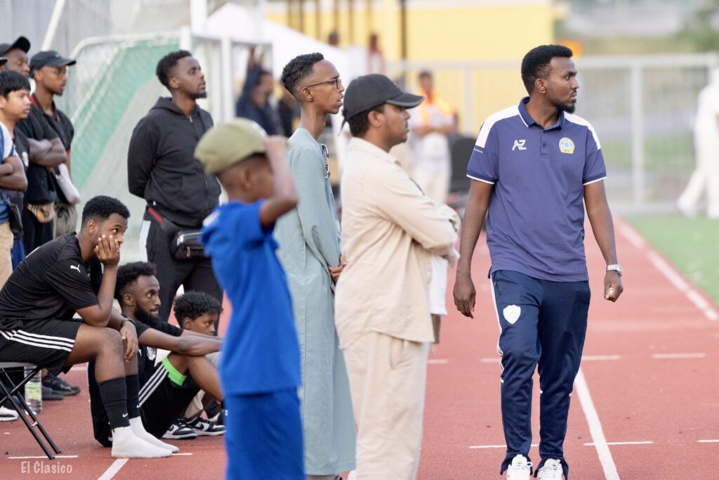 Bild på Som Uniteds tränare och andra vid sidlinjen.