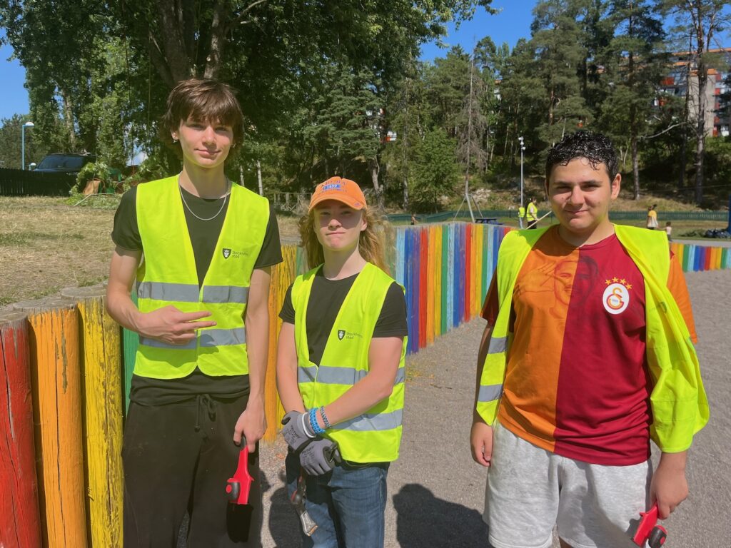 Tre killar i gula varselvästar.