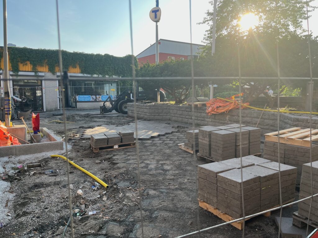 Massa byggmaterial i plastsäckar bakom byggstaket.