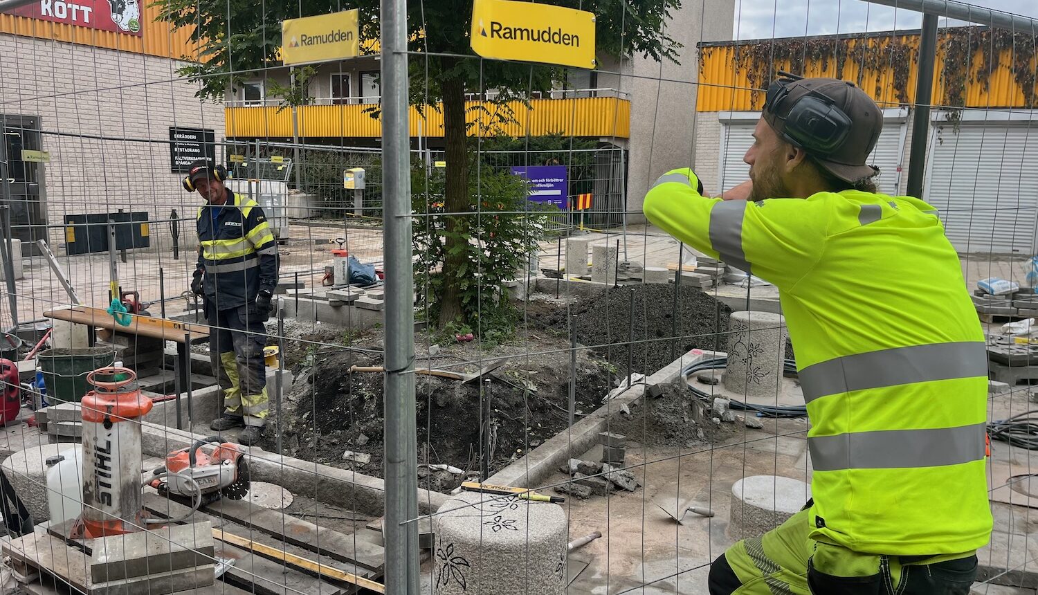 Två anläggningsarbetare pratar med varandra.