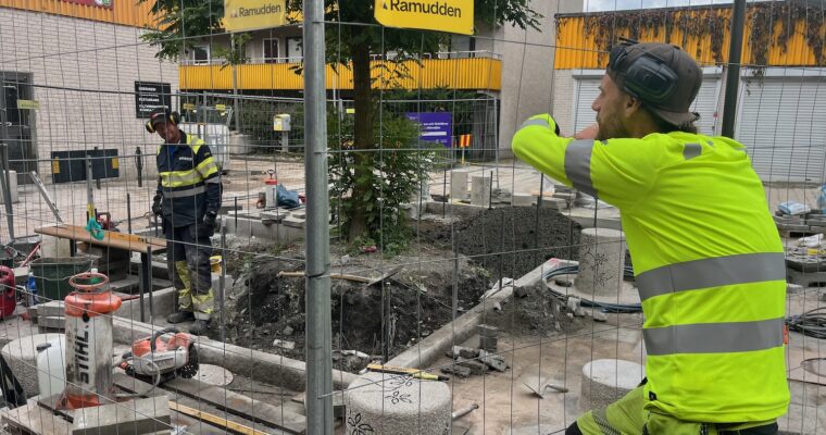 Två anläggningsarbetare pratar med varandra.