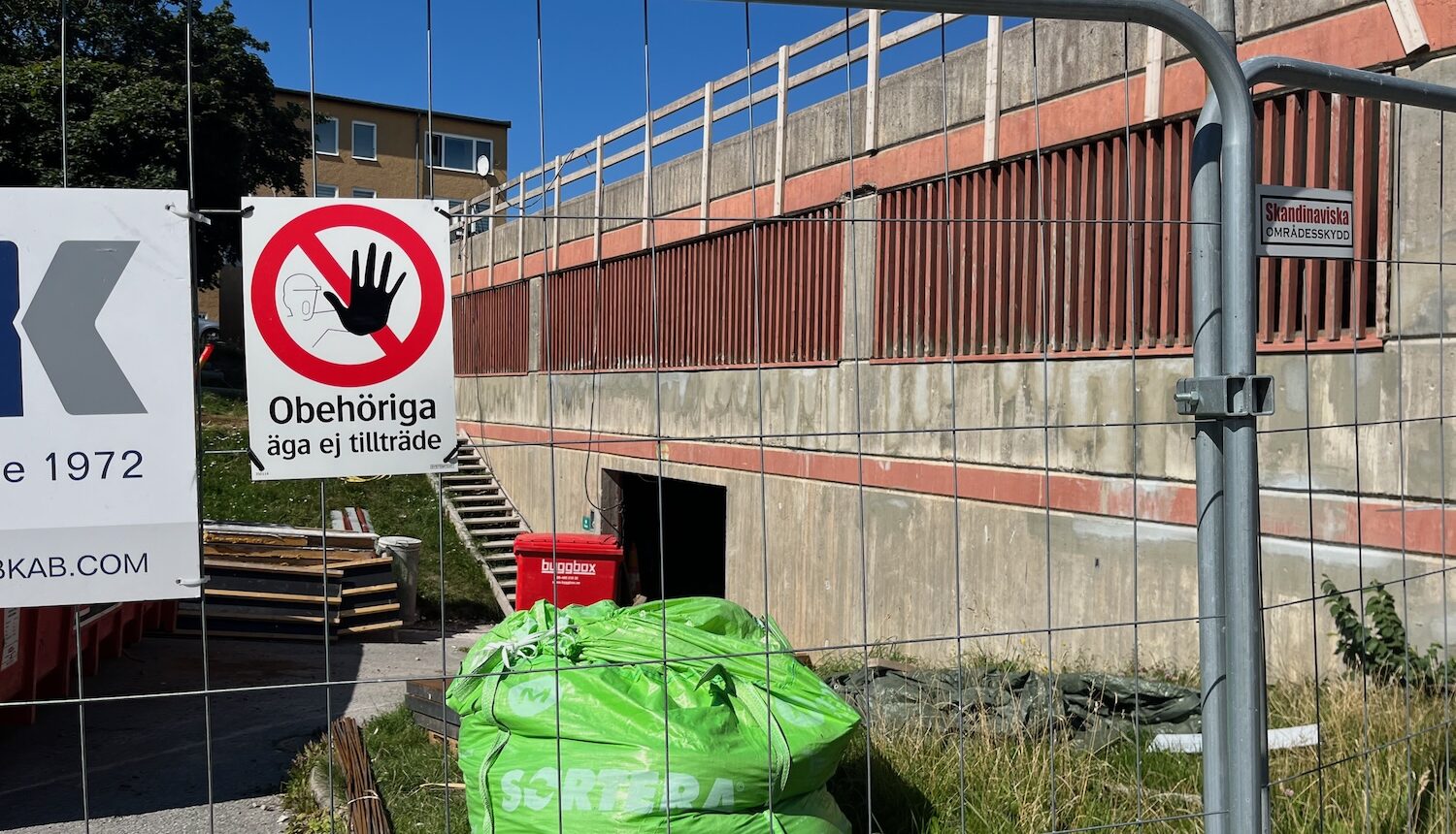 En byggarbetsplats med stängsel och avfallsmaterial i påsar.