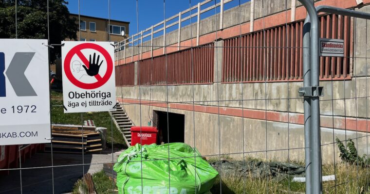 En byggarbetsplats med stängsel och avfallsmaterial i påsar.