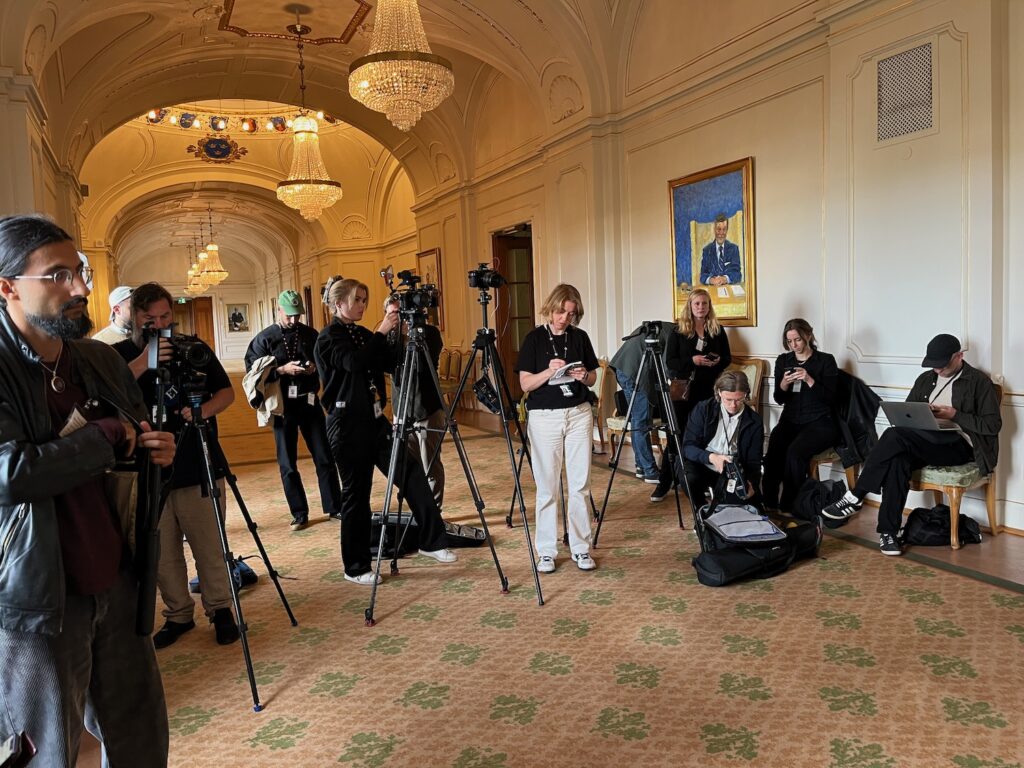 Massa journalister med kameror och mikrofoner.