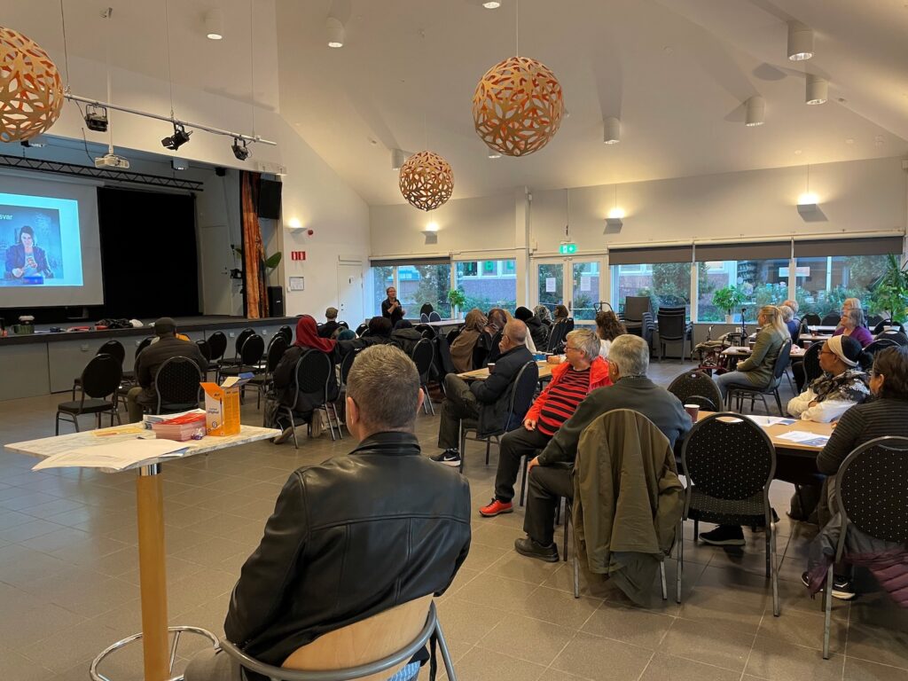 Massa folk i Folkets Husby som lyssnar på en föreläsning.