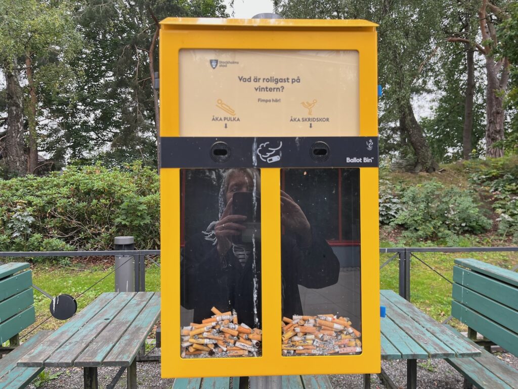 En gul låda där man kan stoppa sina cigarettfimpar och visa om man gillar pulka eller skridskor bäst.