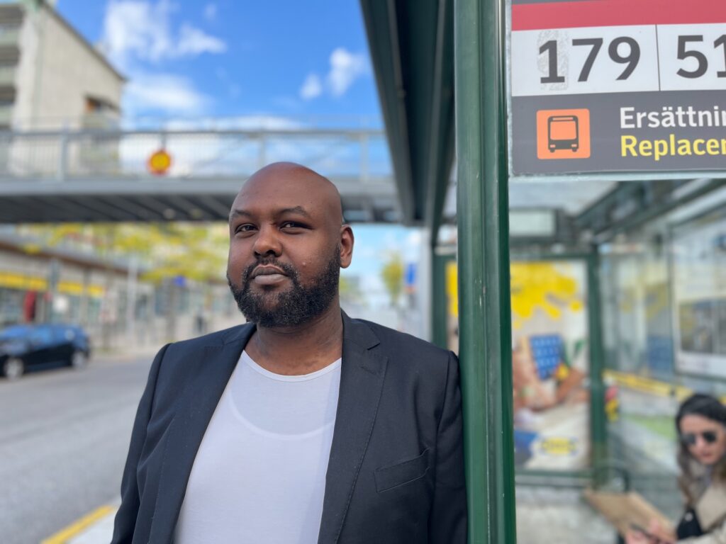Hashim Jama står bredvid en busshållplats för 179:an.