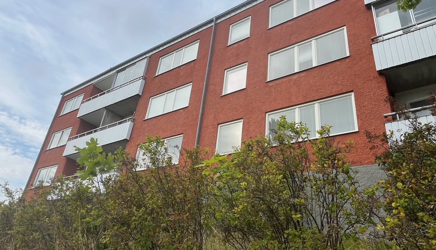 En husfasad i Hjulsta fotograferad nerifrån.