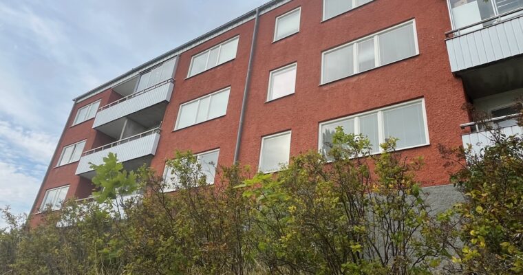 En husfasad i Hjulsta fotograferad nerifrån.