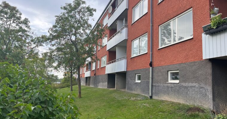 En husfasad i Hjulsta fotograferad nerifrån.