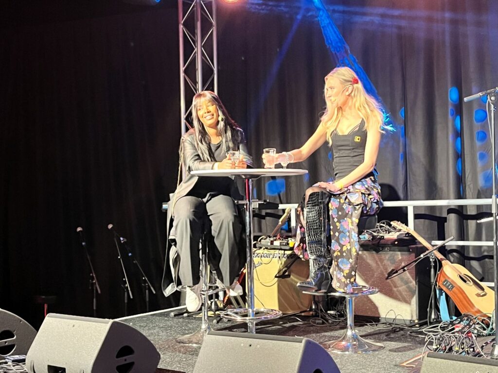 en kvinna intervjuas på scen av en annan kvinna 