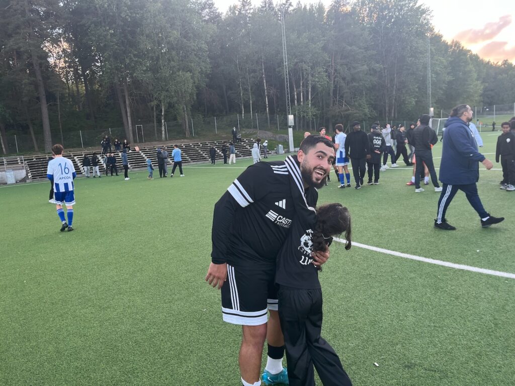 En leende spelare som krmar sin dotter.