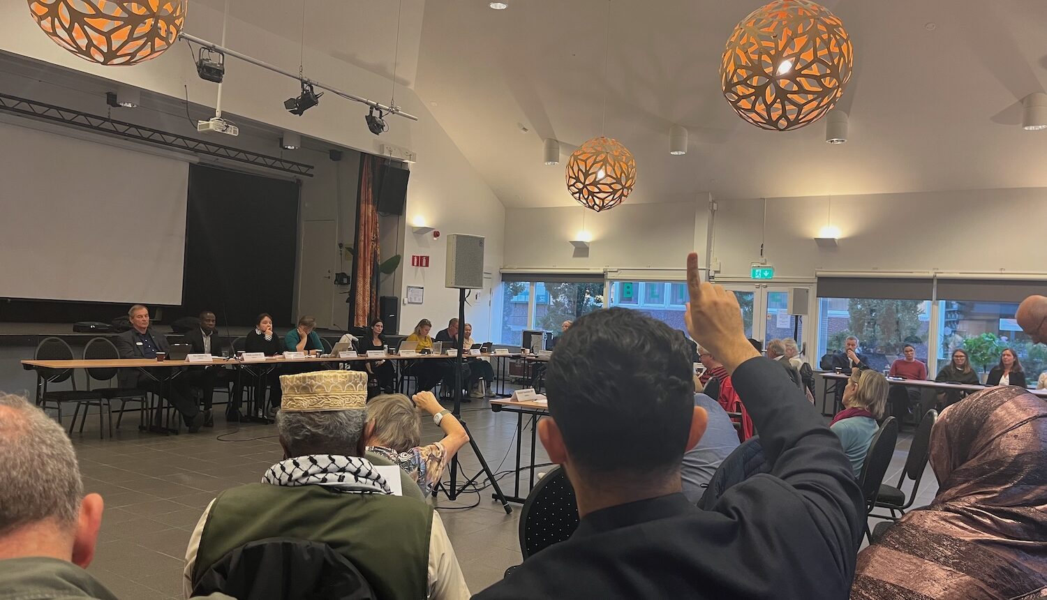 En bild från nämndmötet inne i Folkets Husby. Man ser några bakifrån och politikerna på avstånd.