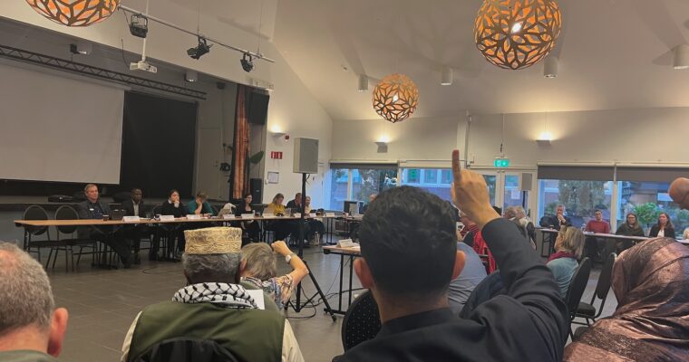 En bild från nämndmötet inne i Folkets Husby. Man ser några bakifrån och politikerna på avstånd.