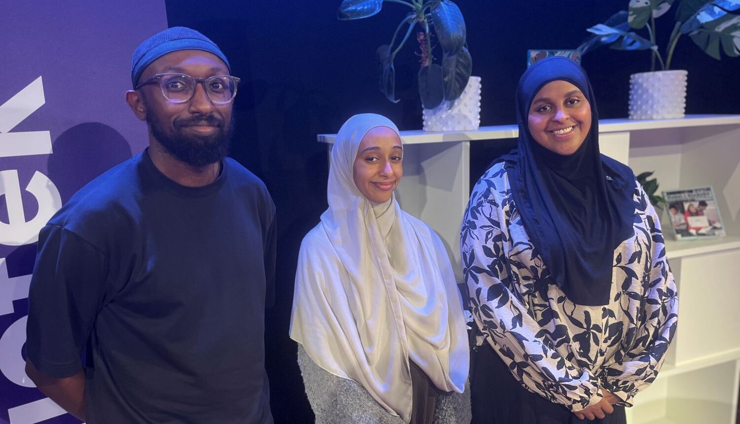 en man och två kvinnor ler mot kameran i en studio
