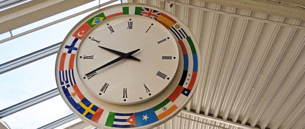 En klockan i taket i Tensta centrum, där olika flaggor utgör ramen.