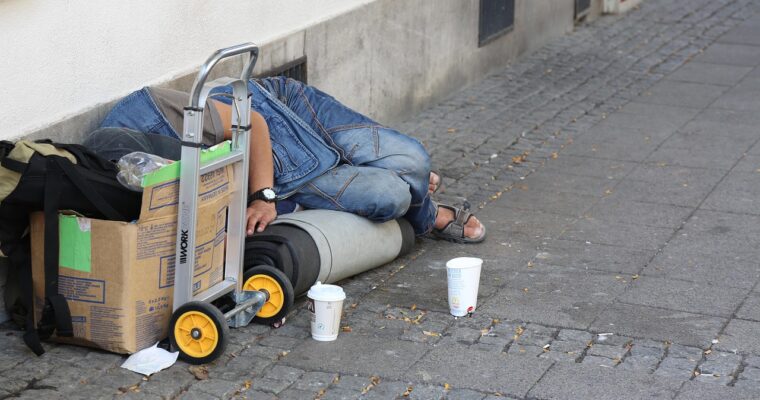 Person som ligger på gatan skymd av en kartong