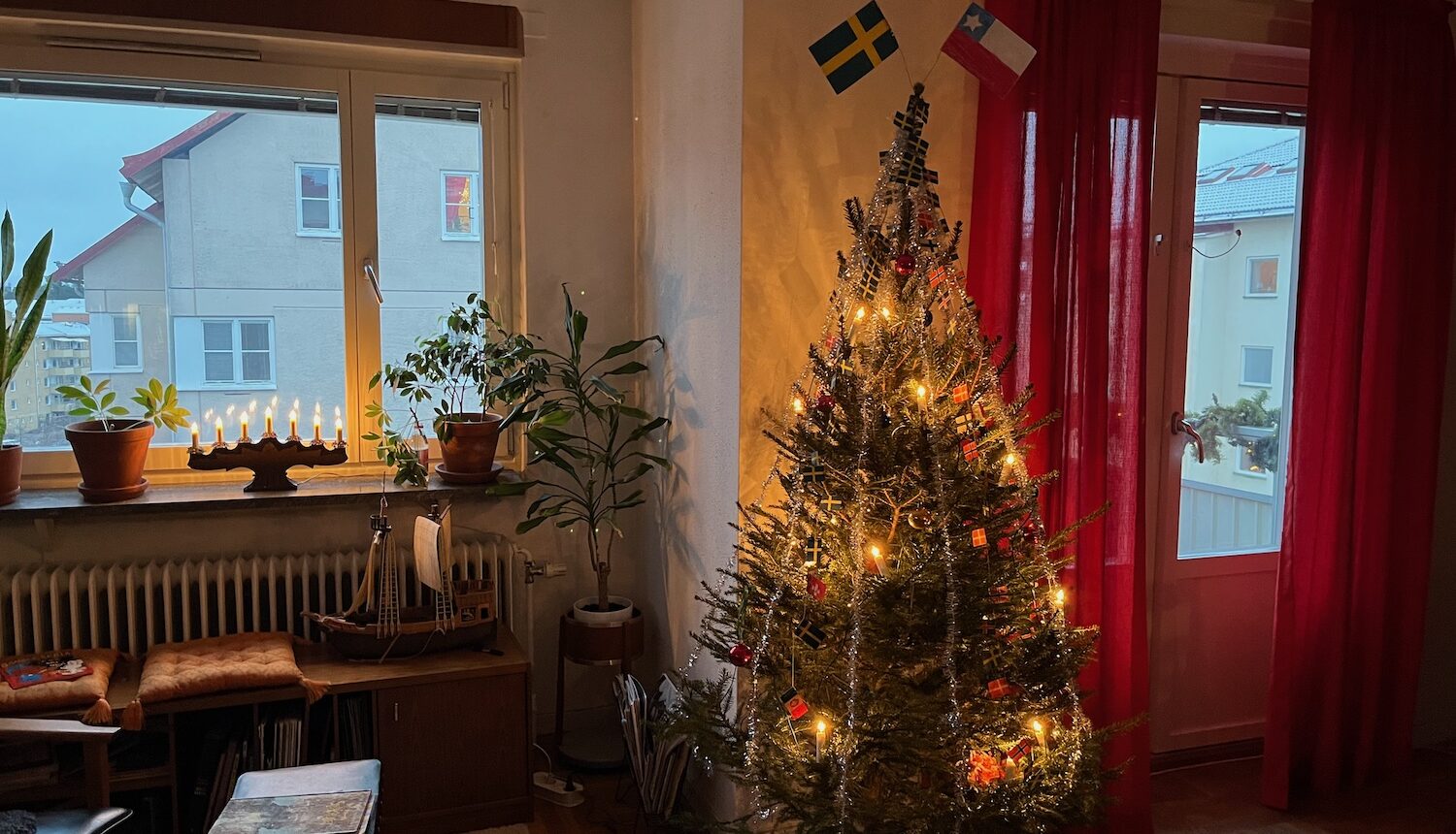 En julgran i ett hem med röda gardiner.