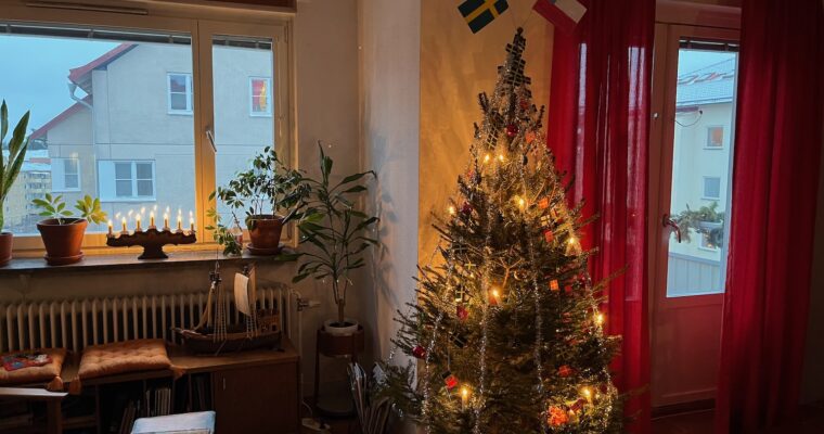 En julgran i ett hem med röda gardiner.