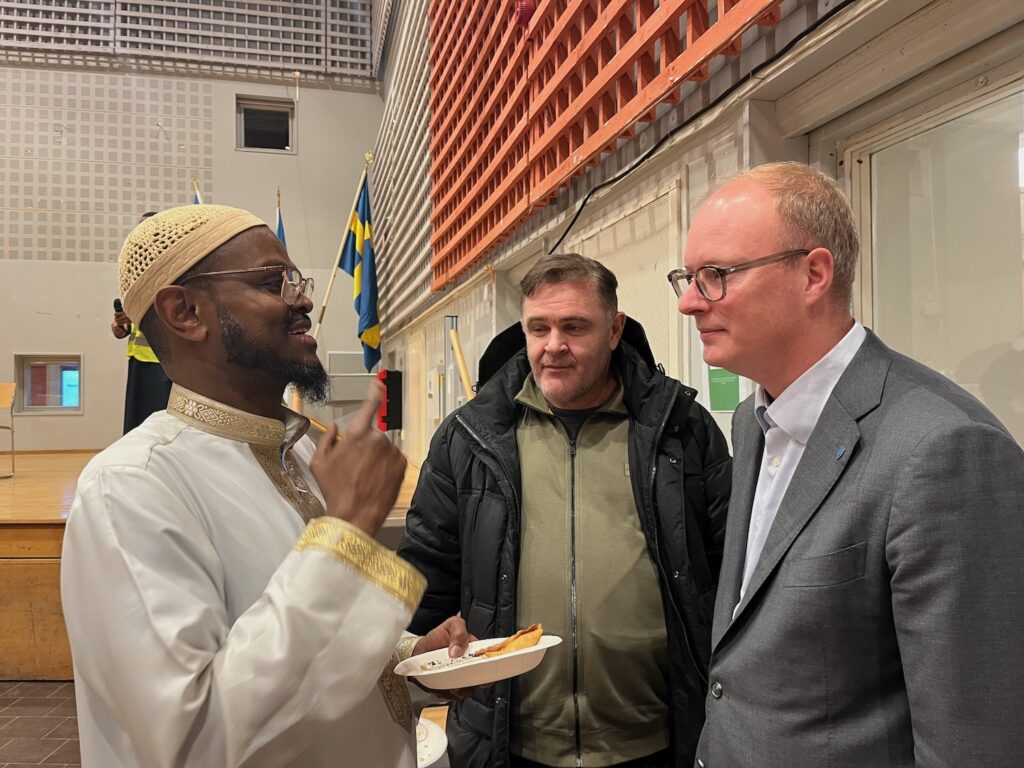 Tre män på bild, en imam och två socialdemokratiska politiker.