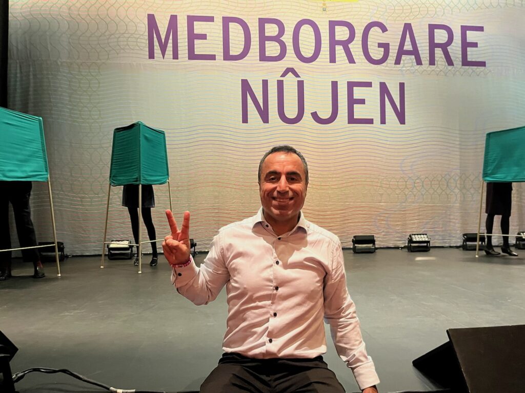 Özz Nûjen på Rivals scen. Han gör segertecknet.