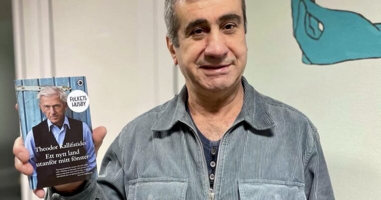 vaktmästaren ler och håller en bok med Folkets Husbys klistermärke på