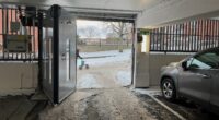 En bild inifrån garaget, man ser någon som drar en rollator utanför.