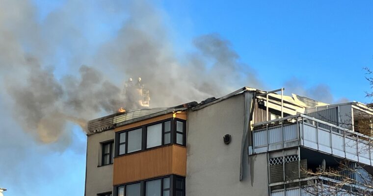 Eldslågor och rök , två badnmän på taket.
