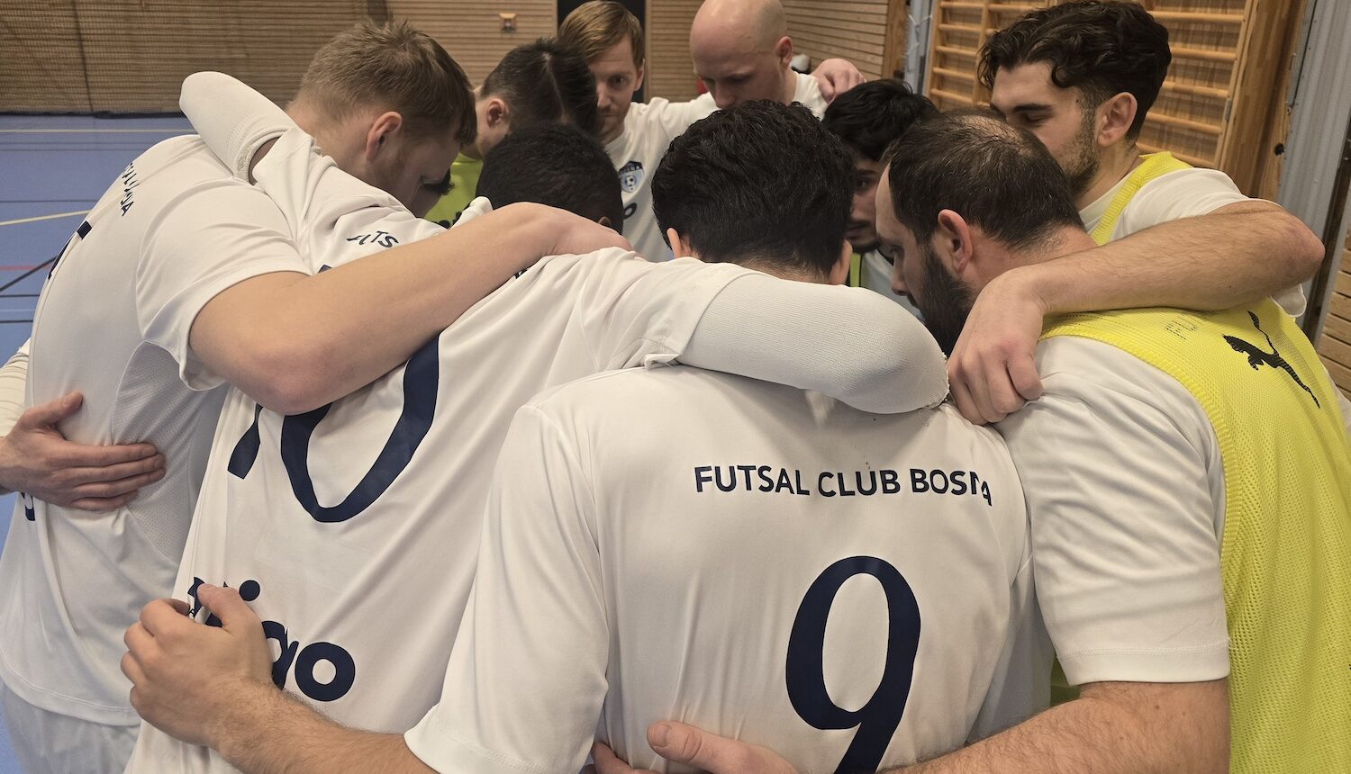 Fotbollspelar står i ring med armarna om varandra.